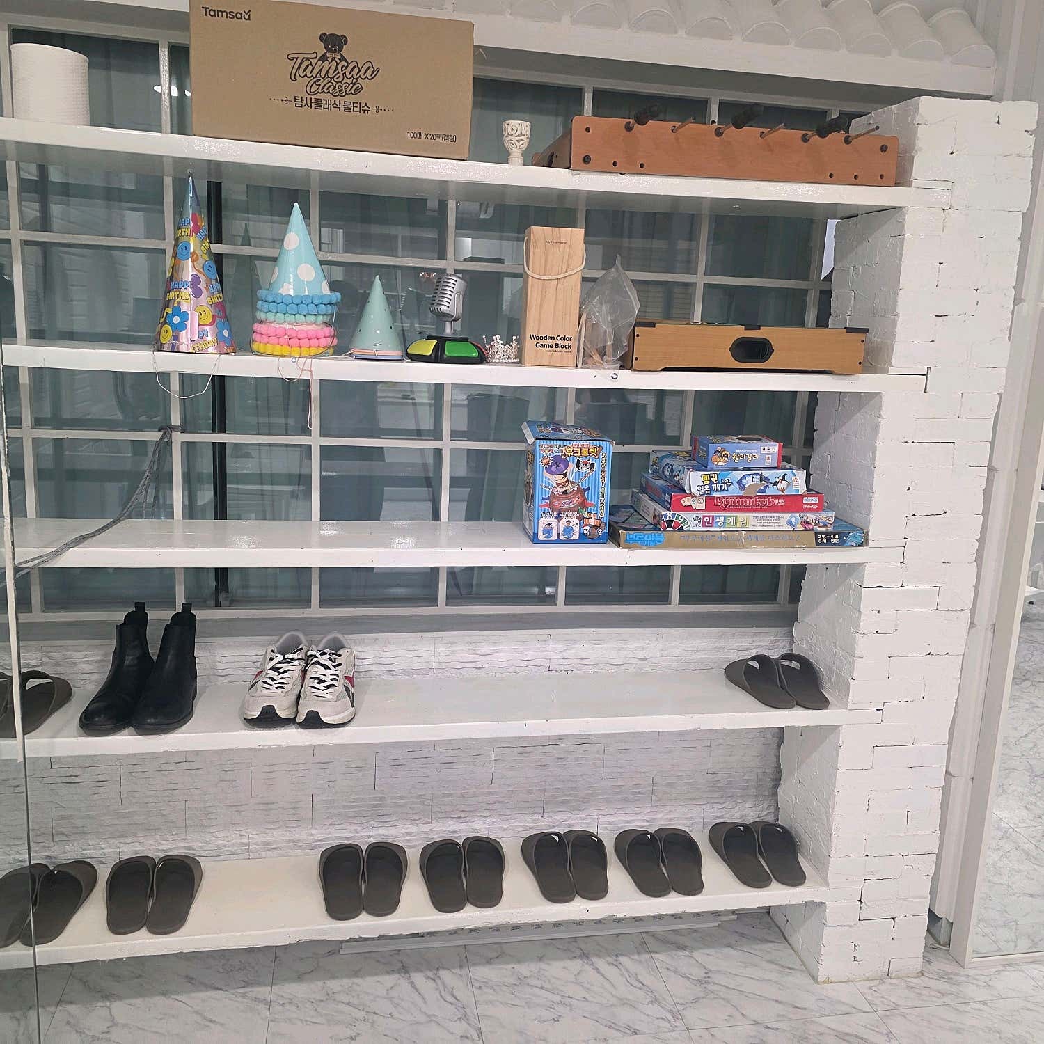보드게임 상자와 파티 모자, 신발이 놓인 선반