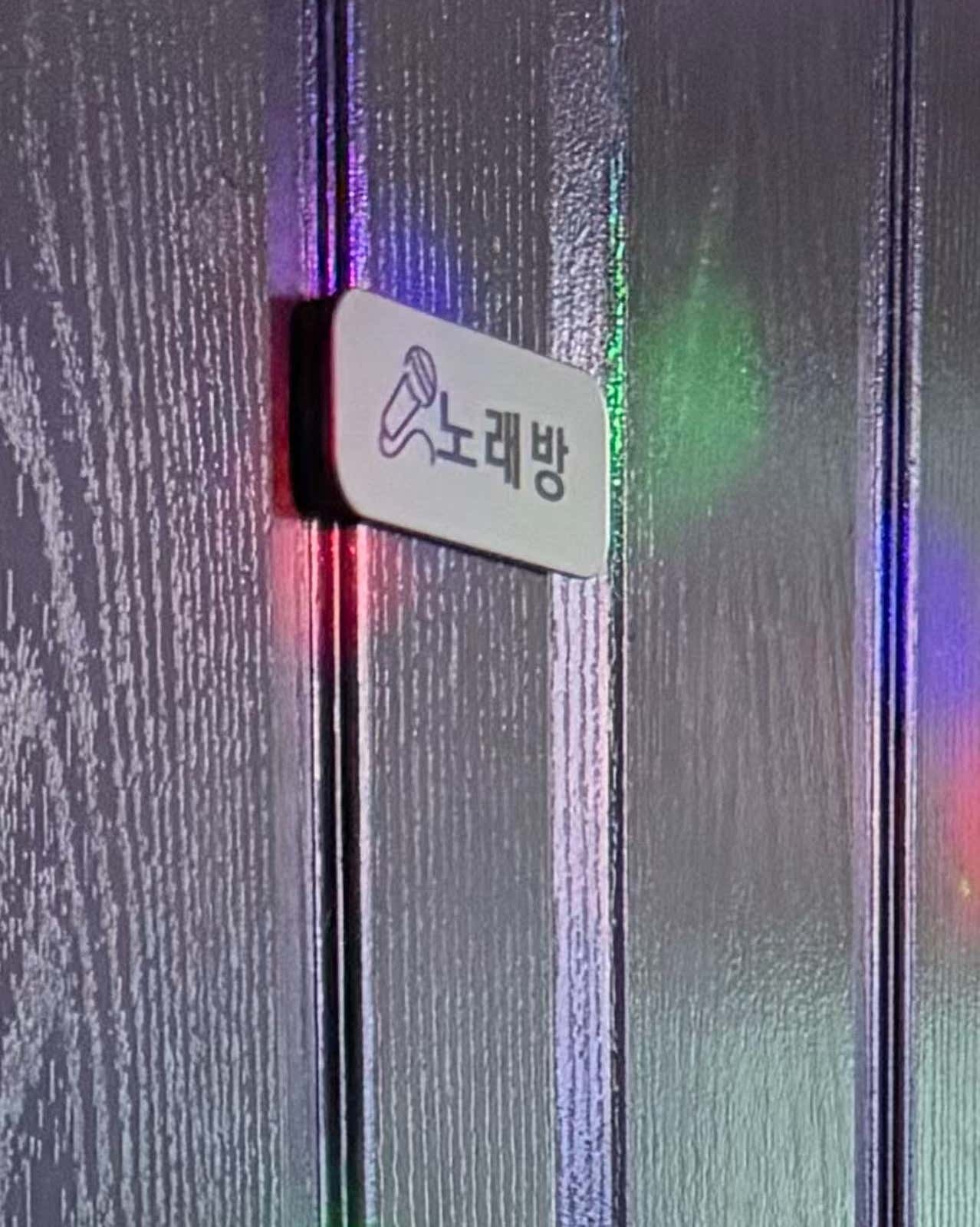 색조명이 비치는 문과 노래방 표지