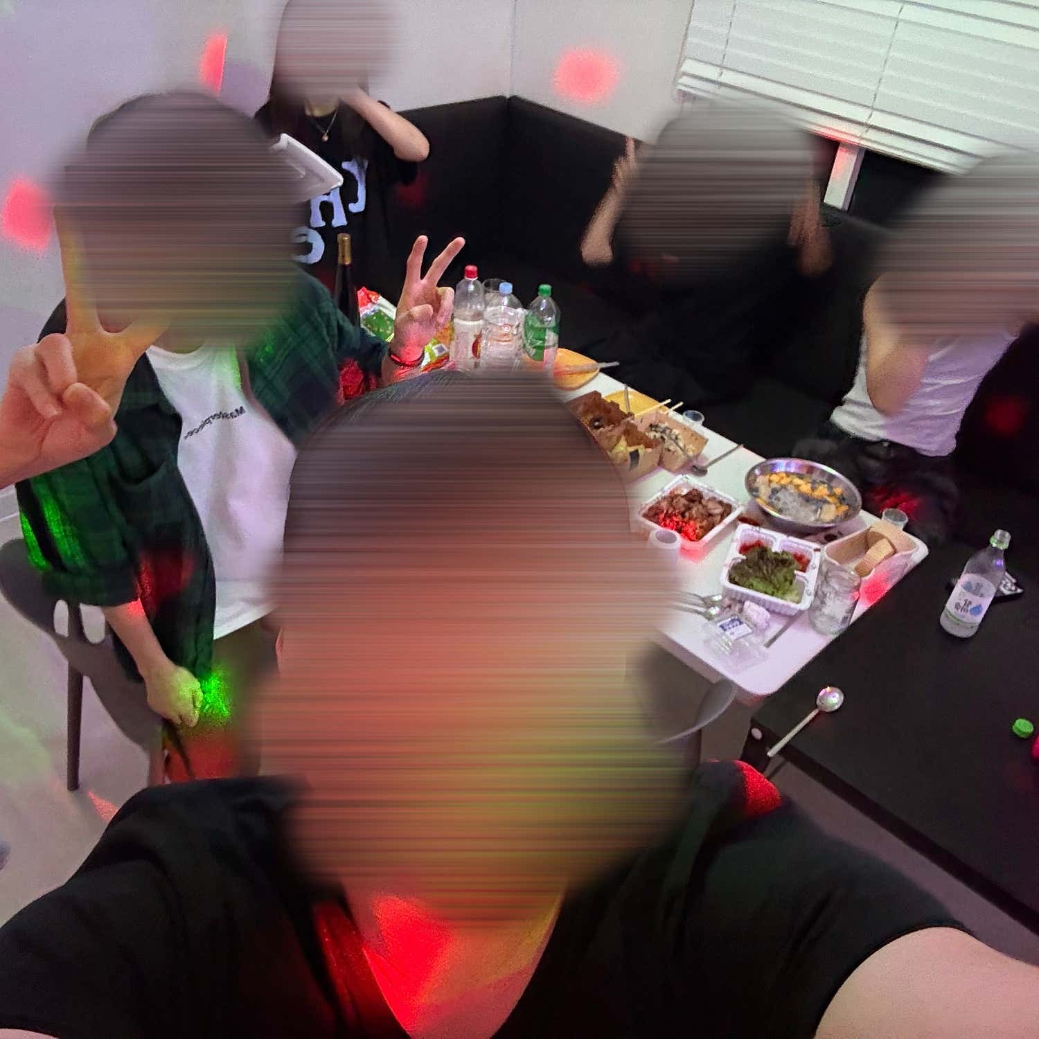 음식이 놓인 테이블 주위에 모인 친구들과 색 조명