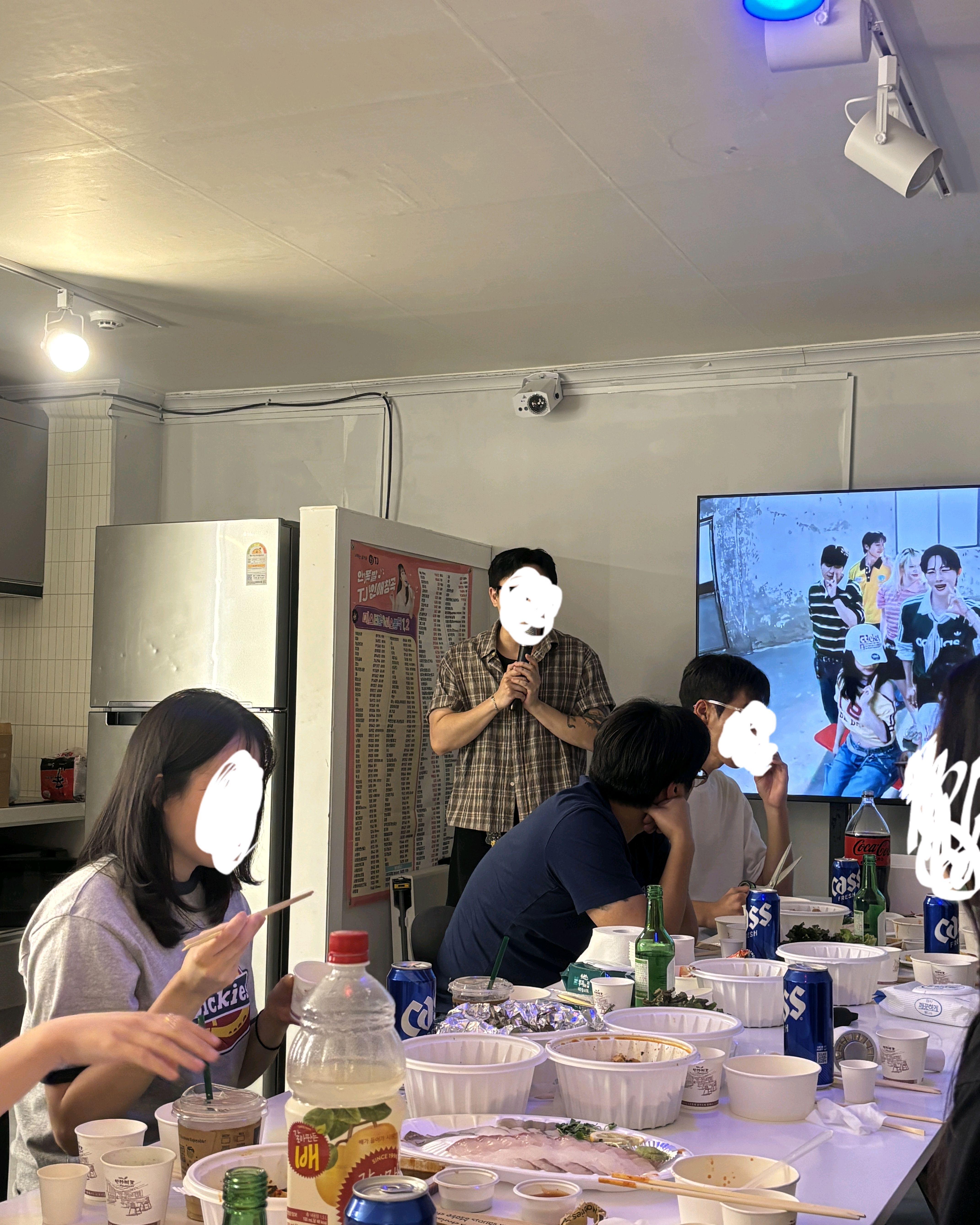 긴 흰색 테이블에 둘러앉아 식사하는 단체