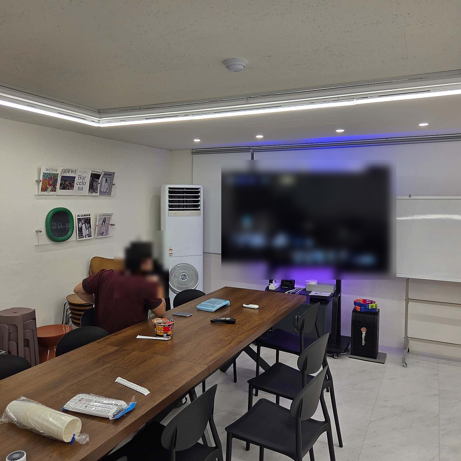 긴 테이블 앞 화면으로 노래를 고르는 공간